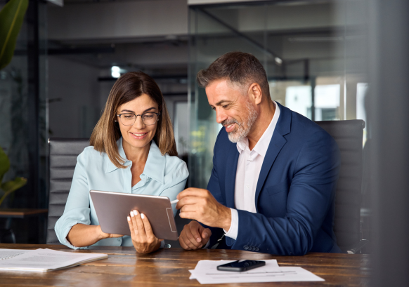 meeting of two people reviewing documents on a tablet